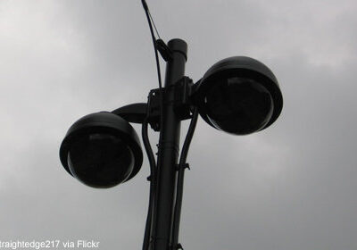 Photo of two domed cameras against a gray sky