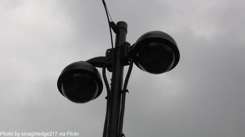 Photo of two domed cameras against a gray sky