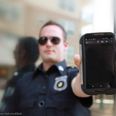 Police officer holding cell phone