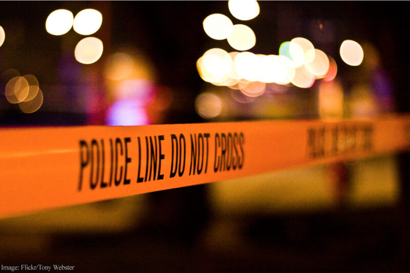 Police tape with lights in background