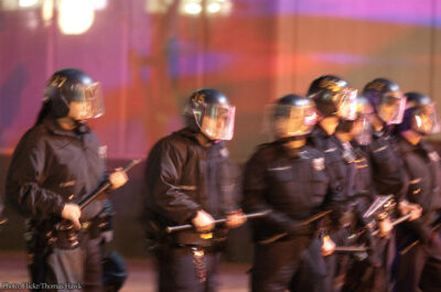 Police in riot helmets holding batons