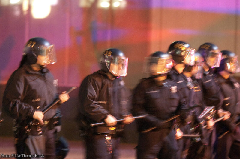 Police in riot helmets holding batons