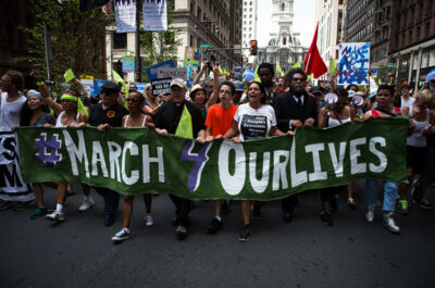 Crown marching with #March 4 Our Lives sign