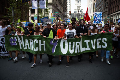 Crown marching with #March 4 Our Lives sign
