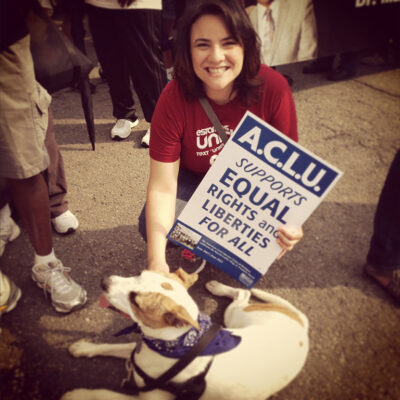 Rana Elmir and her pit bull, Olivia, at a rally with an ACLU sign