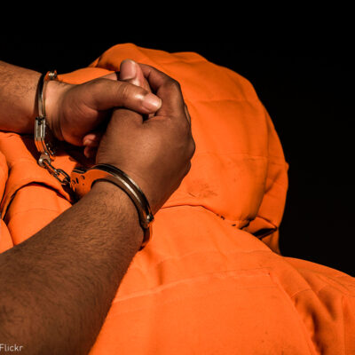 Man with hands cuffed in his lap