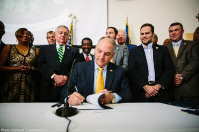 Gov. Edwards signs historic justice reinvestment legislation in a room full of advocates.