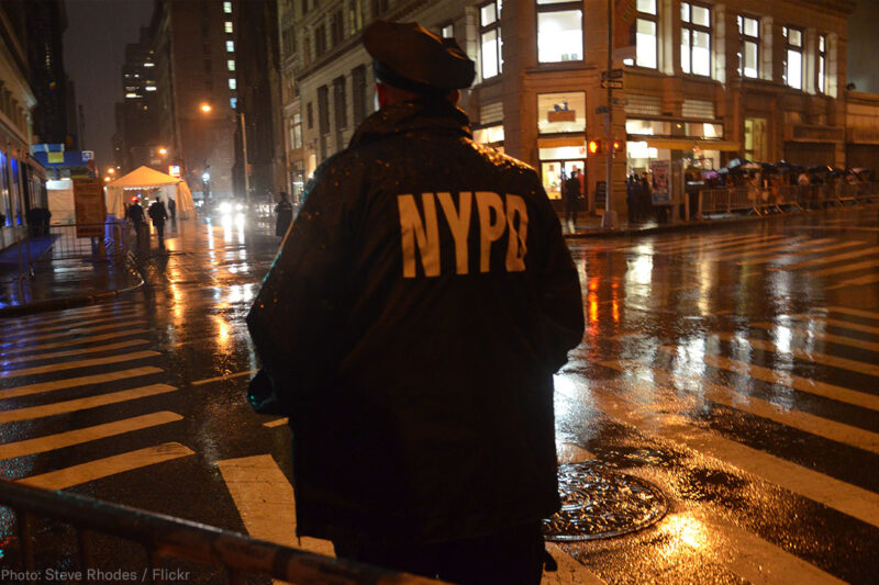 NYPD Officer standing on corner at night