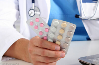 Pharmacist holding pack of birth control pills