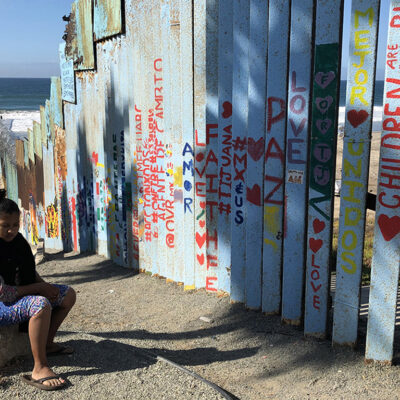 Woman seated near fence
