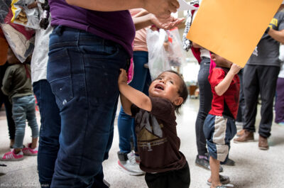 Child holding onto parent's leg
