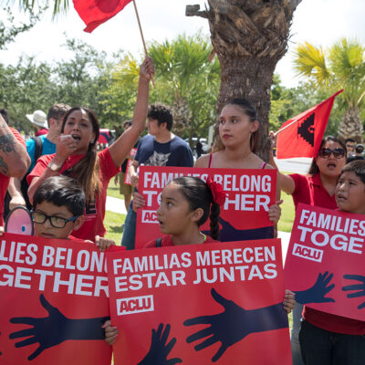 Demonstrators carrying signs with the text "Families Belong Together"