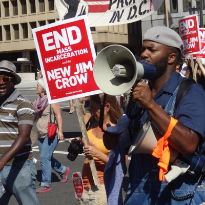 Demonstrators carry signs advocating an end to mass incarceration
