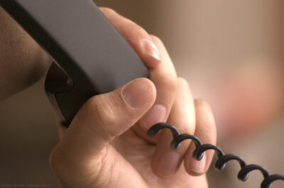 Hand holding landline phone