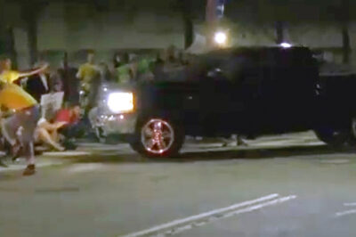 Protesters blocking an entrance to the Donald W. Wyatt Detention Facility begin to move as a pickup truck approaches