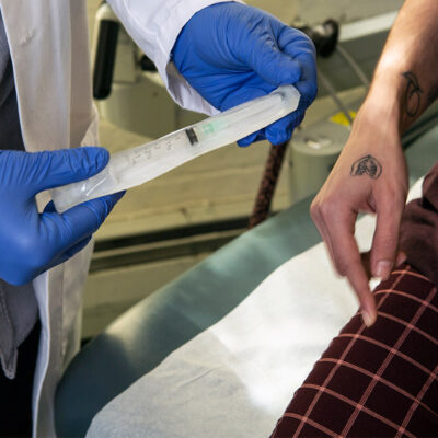 A doctor showing a patient a syringe used to inject testosterone
