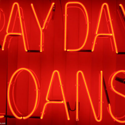 A neon sign with the text "payday loans"