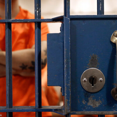 Detainees wait in a cell for an appearance in court