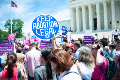A crowd of pro-choice protesters standing outside the Supreme Court holding up signs that read "Keep Abortion Legal," and "Abortion is a Human Right" among other signs.