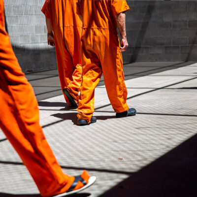 inmates walk the yard during recreation time in a county jail.