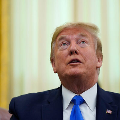 Donald Trump looking upward while speaking in the Oval Office.