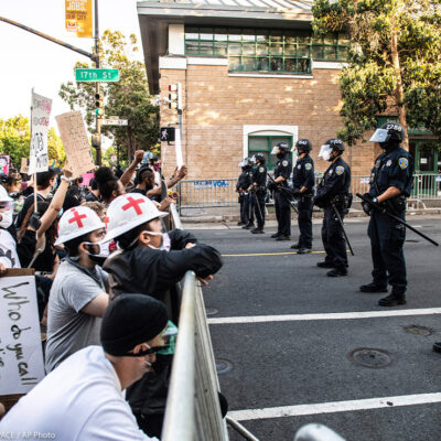 Protestors demonstrate in front of a line of police officers outside of Mission Police Station in San Francisco after the death of George Floyd