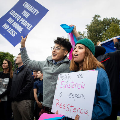 Demonstrators carrying signs advocating for the rights of LGBTQ people.