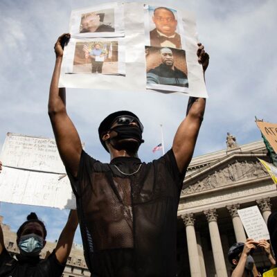 A protester holds up a sign with picutres of Black Americans who have been killed by police, taken in New York City June 2, 2020