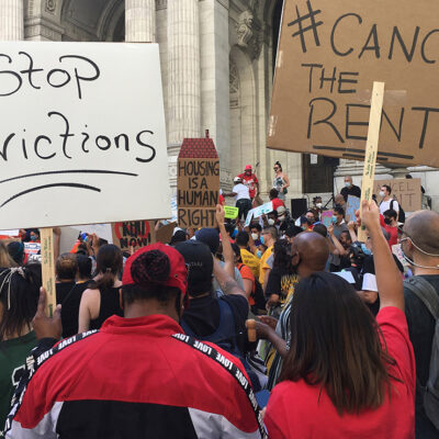 Protesters demonstrating with signs calling for rent relief and an end to evictions.