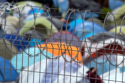Barbed wire fence at a refugee camp for migrants and asylum seekers in Matamoros, Mexico, October 2019. Guillermo Arias for the ACLU.