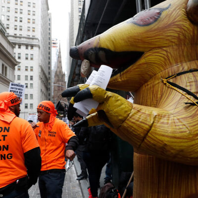 A giant inflatable rat stands in front of a non-union worksite where union workers protested during a May Day rally