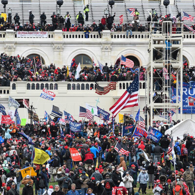 Insurrectionists amassing on the steps, walls, balconies, and grounds of the Capitol Building.