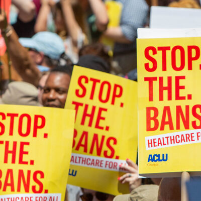 Protestors holding signs calling for the end of abortion bans.