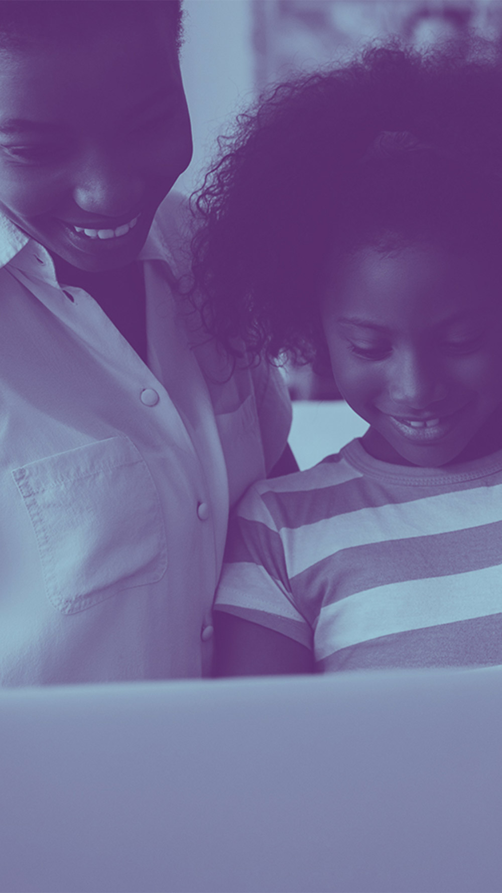 A picture of a black family smiling together as they stare at a computer, with a blue overlay on the photo.