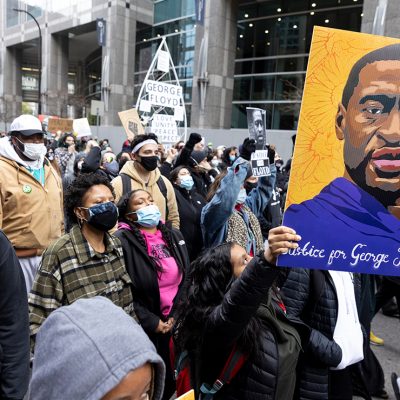Demonstrators carry signs demanding justice for George Floyd.