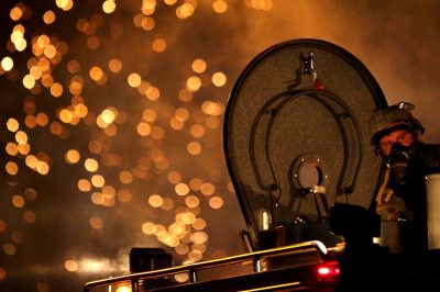 A law enforcement officer watches from an armored vehicle after a device was fired to disperse a crowd during a protest.