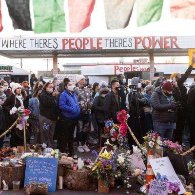 A sign that reads "where there's people there's power" over a crowd of people