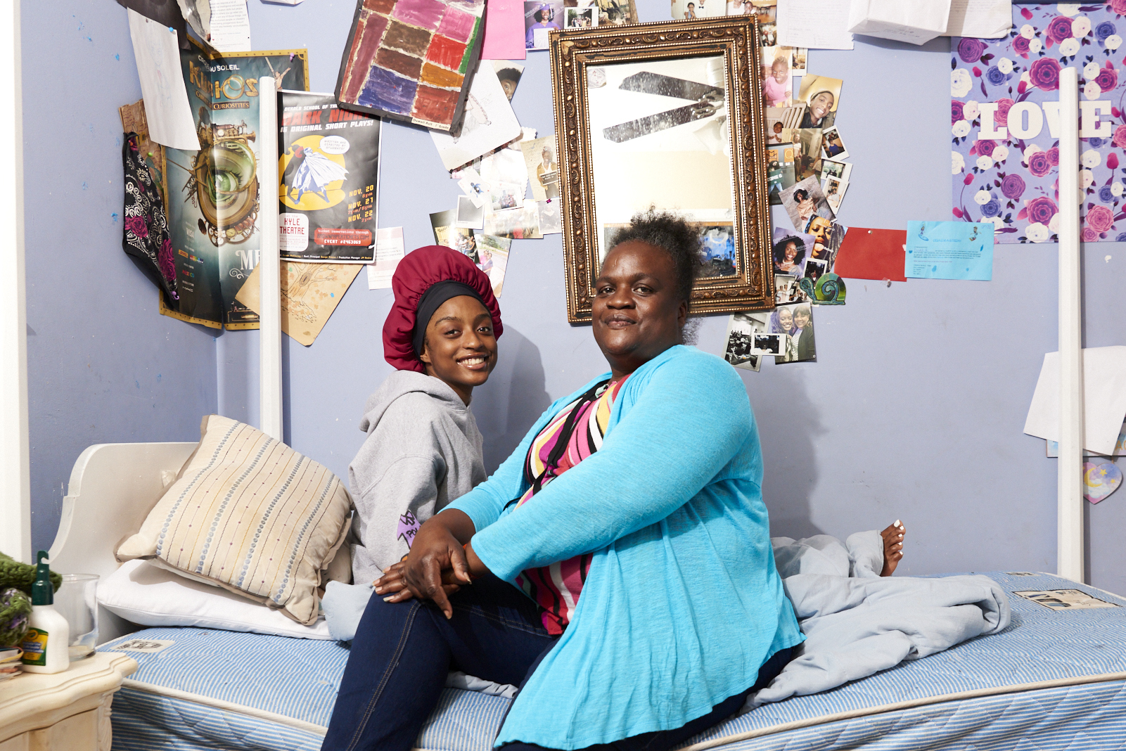 Mother and child sitting on a bed in a bedroom
