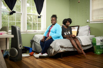 Mother and child sitting on a bed in a bedroom