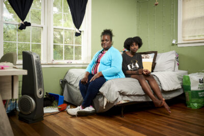 Mother and child sitting on a bed in a bedroom