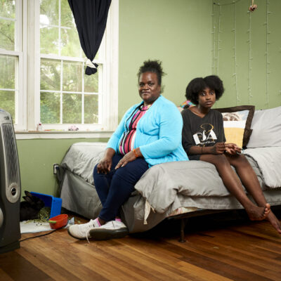 Mother and child sitting on a bed in a bedroom