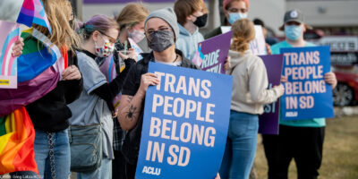 Protestor holds sign reading “Trans People Belong In SD” during trans rights rally.