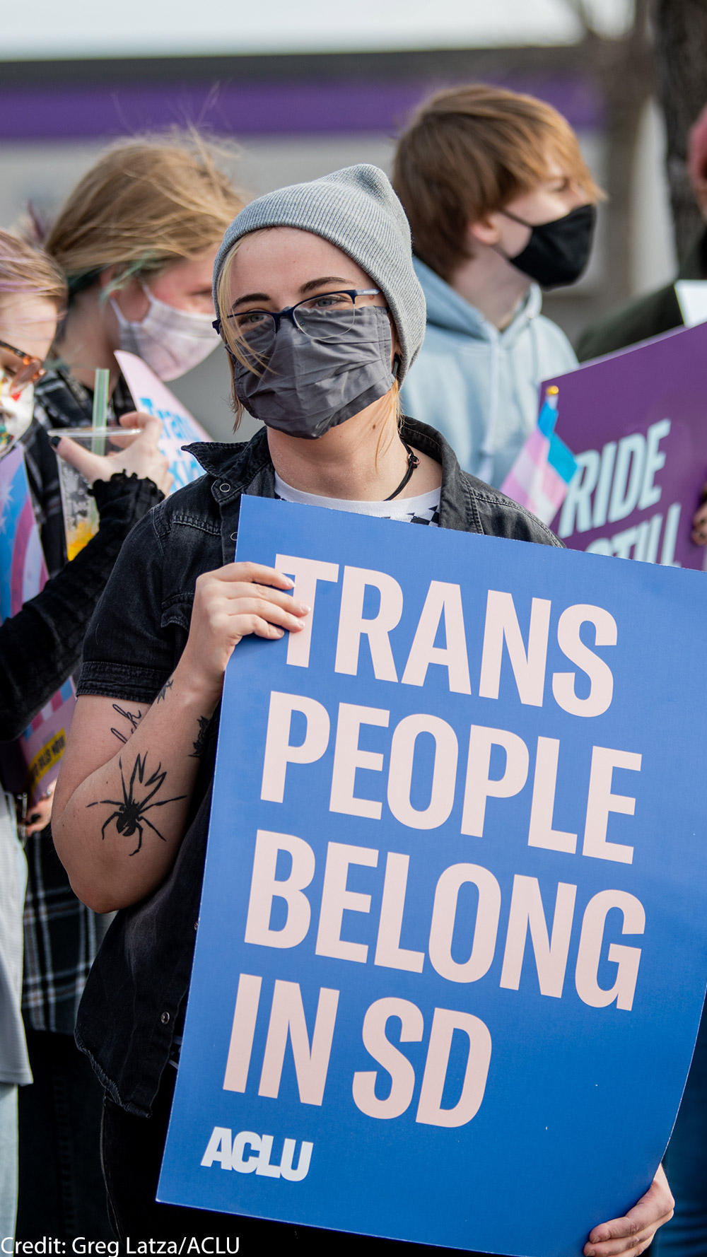Protestor holds sign reading “Trans People Belong In SD” during trans rights rally.