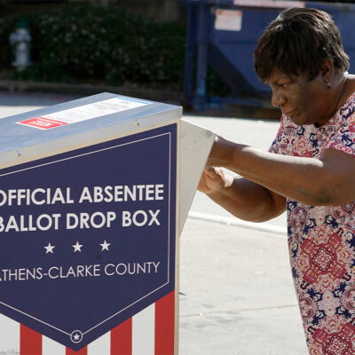 An African-American woman dropping their ballot off during early voting in Athens, Ga.