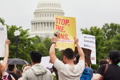 A group of people holding reproductive rights signs in front of the Capitol Building.