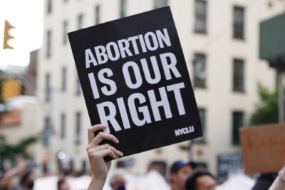 A person holding up a sign saying "Abortion is Our Right."