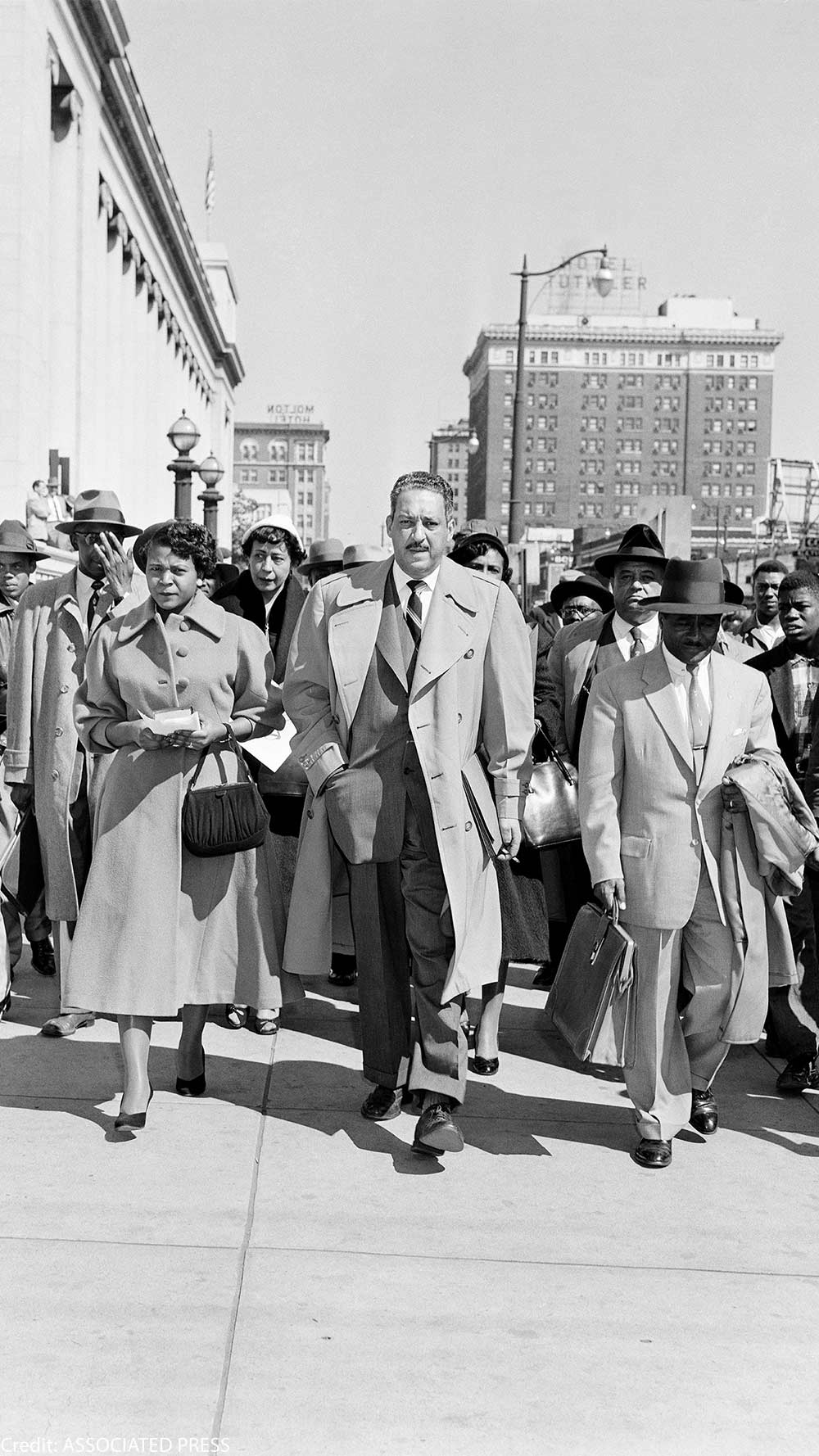 Autherine Lucy, left, front, 26-year-old student at the University of Alabama, arrives at U.S. District Court for the hearing of her petition for an order requiring the school to re-admit her to classes in Birmingham, Ala., Feb. 29, 1956. With Lucy are her legal team, Thurgood Marshall, tall man at center, and Arthur Shores, carrying coat at right.