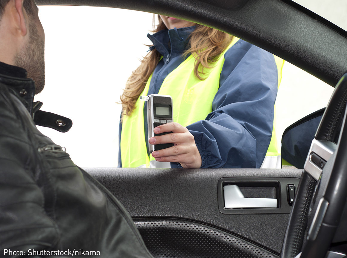 Police performing drunk driving test on driver