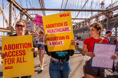 Three demonstrators holding pro-abortion signage.