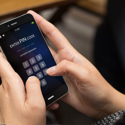 A person trying to enter security pin code on a cell phone screen.